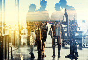 Multiple exposure shot of a group of businesspeople superimposed over a city background